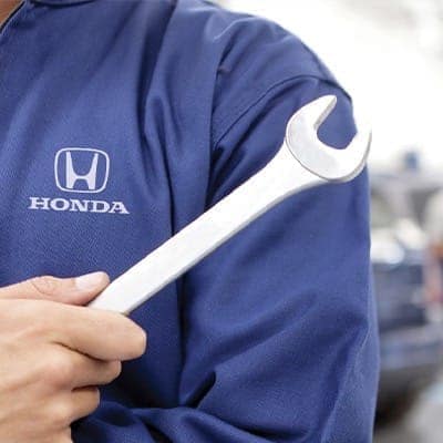 Honda service technician holding a wrench