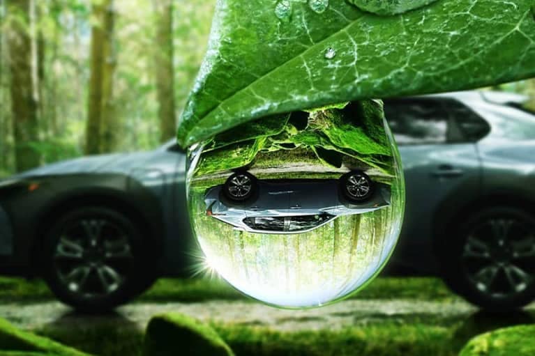 2022 Subaru Solterra-sideview in forest w raindrop mirror effect-silver mobile