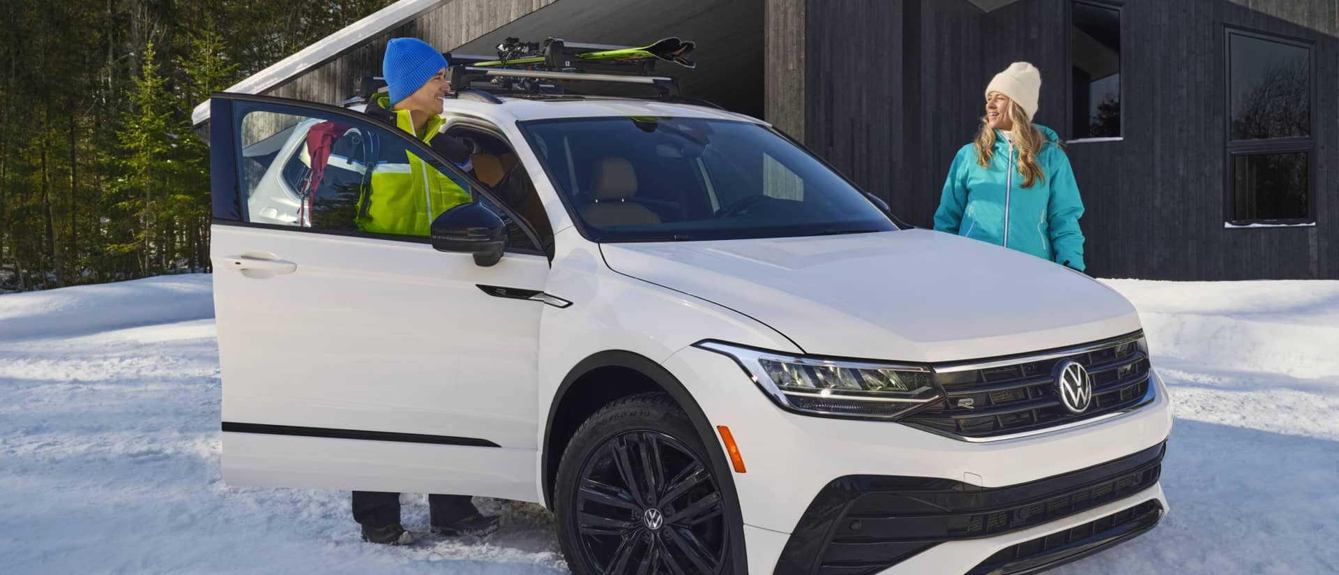 2023 Volkswagen Tiguan with parents standing around it in the snow