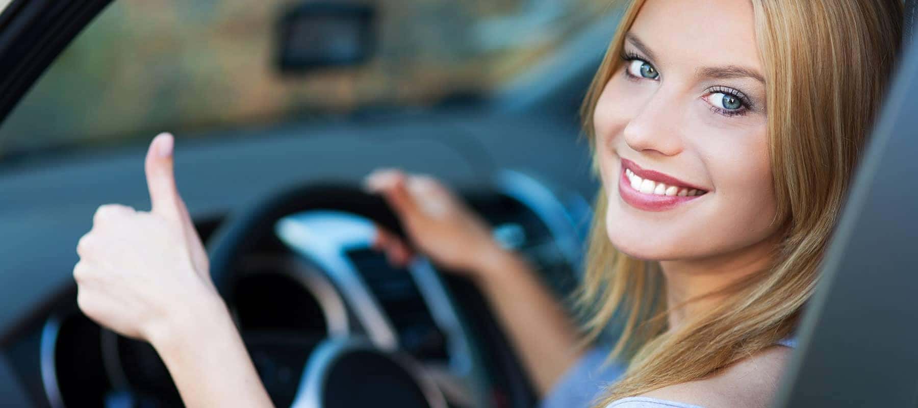 Person in car giving thumbs up