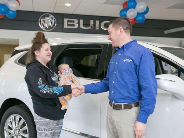Woman holding baby shaking sales representative's hand