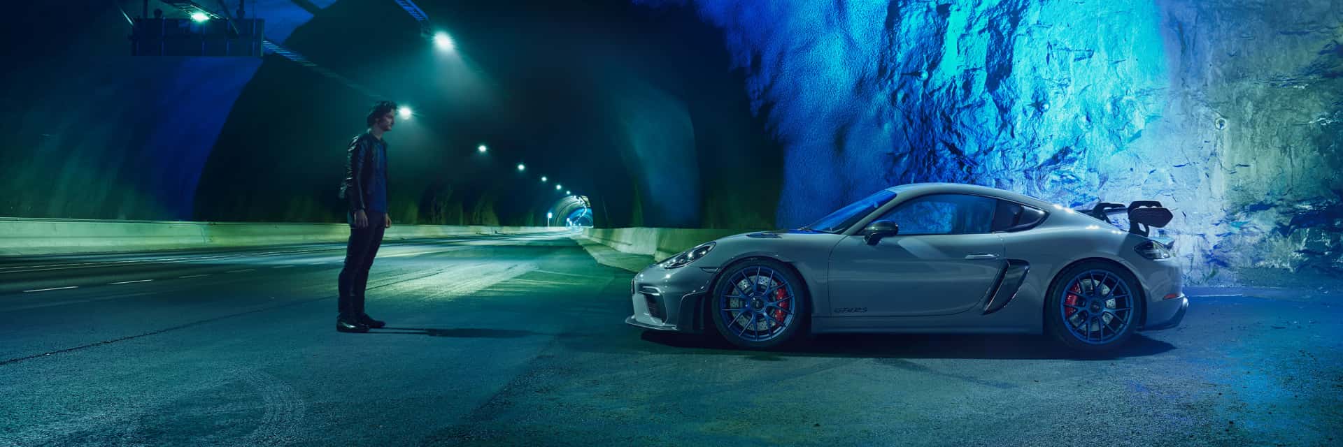 2025-porche-718-cayman-parked-in-a-tunnel-and-illuminated-by-green-and-blue-lights