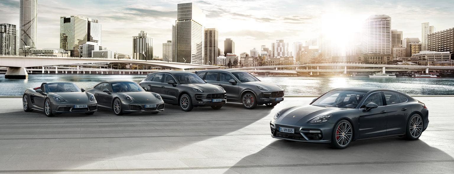 porsche lined up with a modern city skyscape in the background