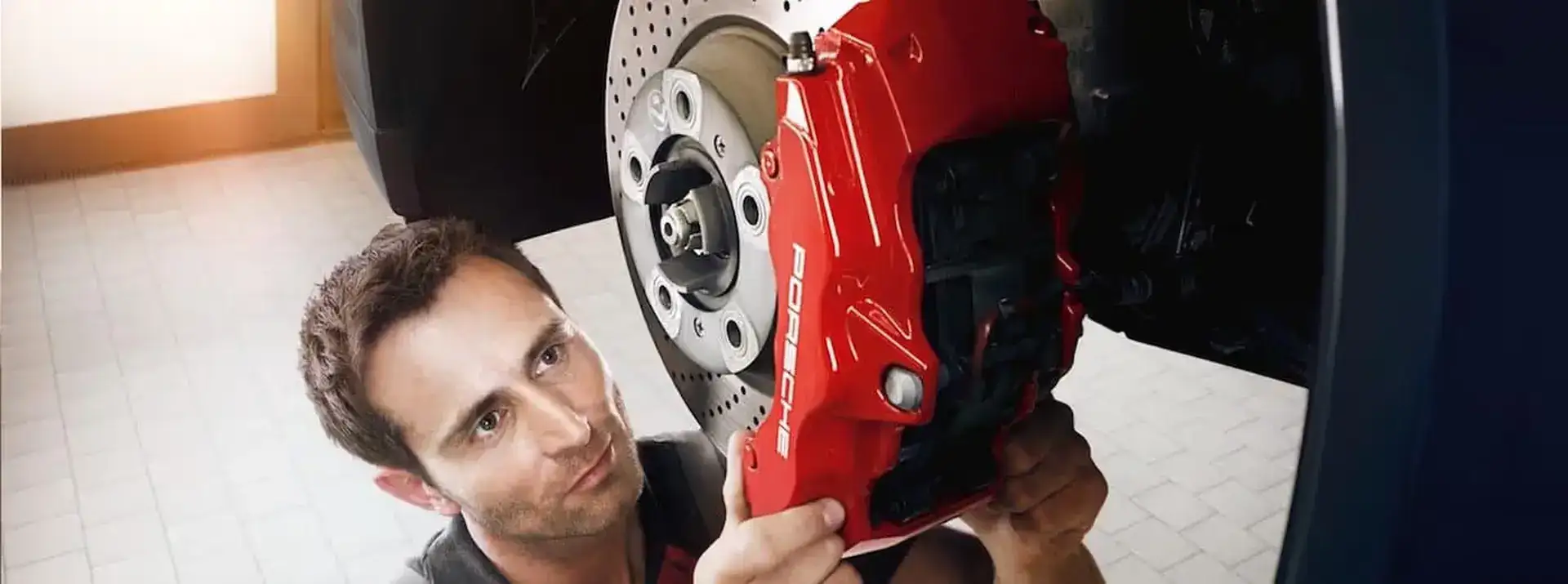 Mechanic inspecting Porsche brakes