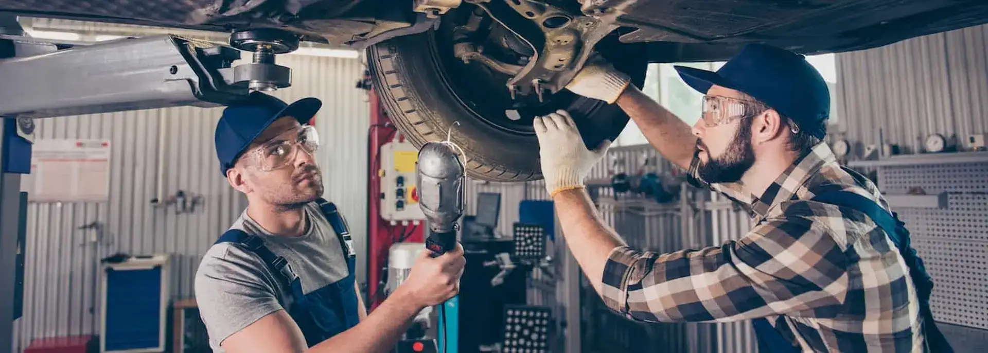 Mechanics Inspecting Car Tire
