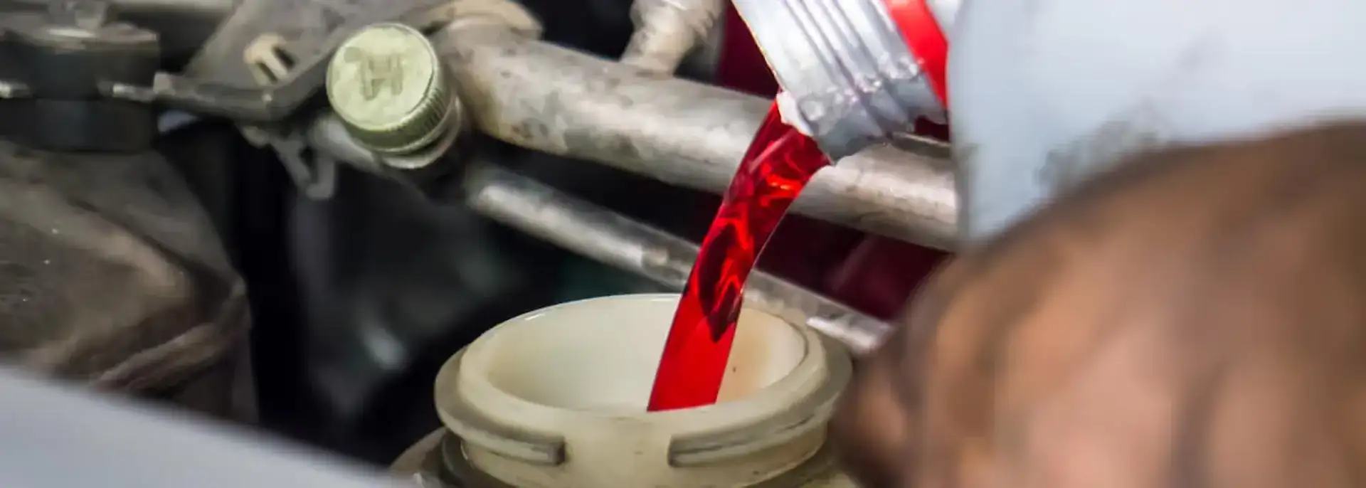Transmission fuid being poured into a car