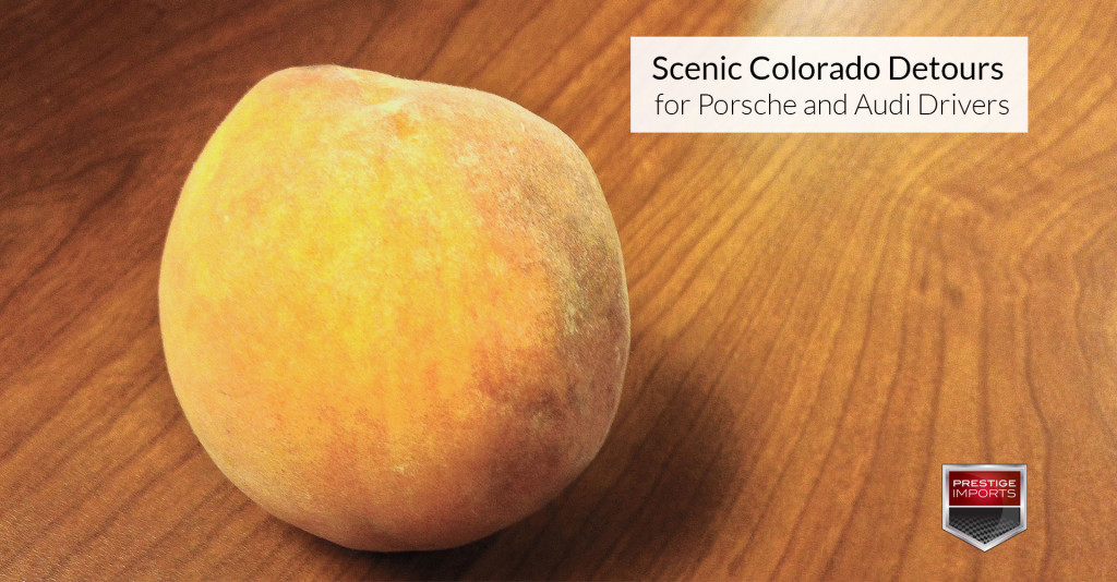 Palisade peach set on a wooden table. Used to illustrate the article, "Scenic Colorado Detours for Porsche and Audi Drivers"