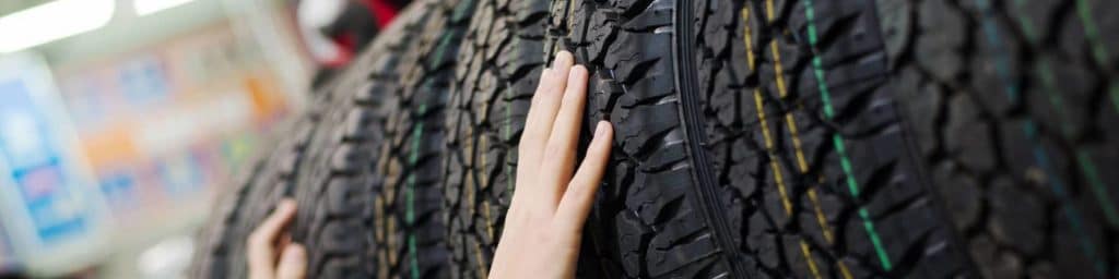 Hands Inspecting Tires in a Tire Store slim