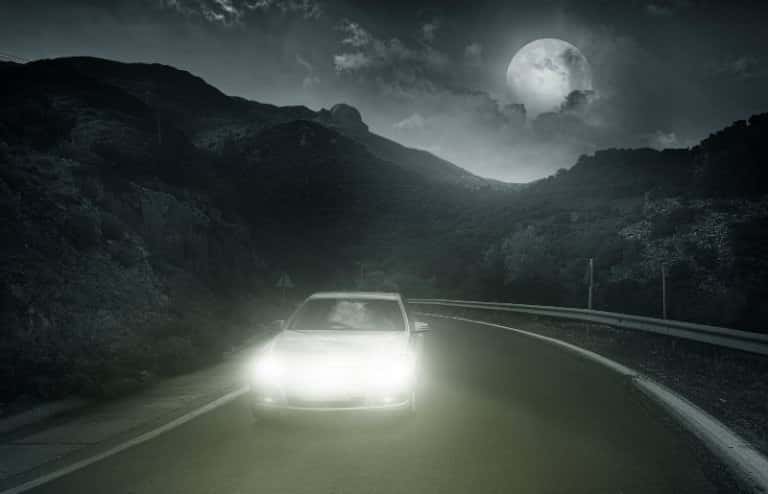 car driving on road at night in mountains