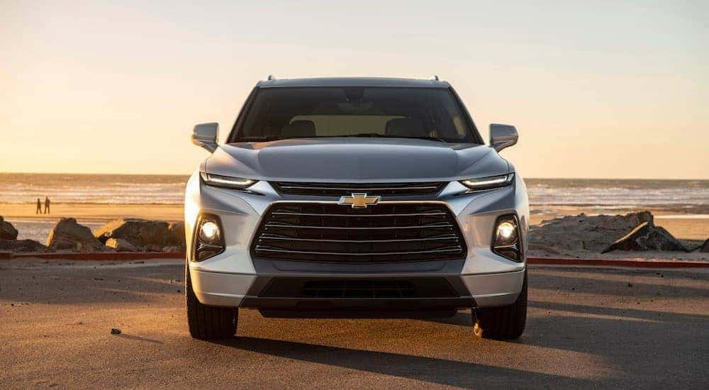 A grey 2019 Chevy Blazer is parked in front of a beach during a sunset.