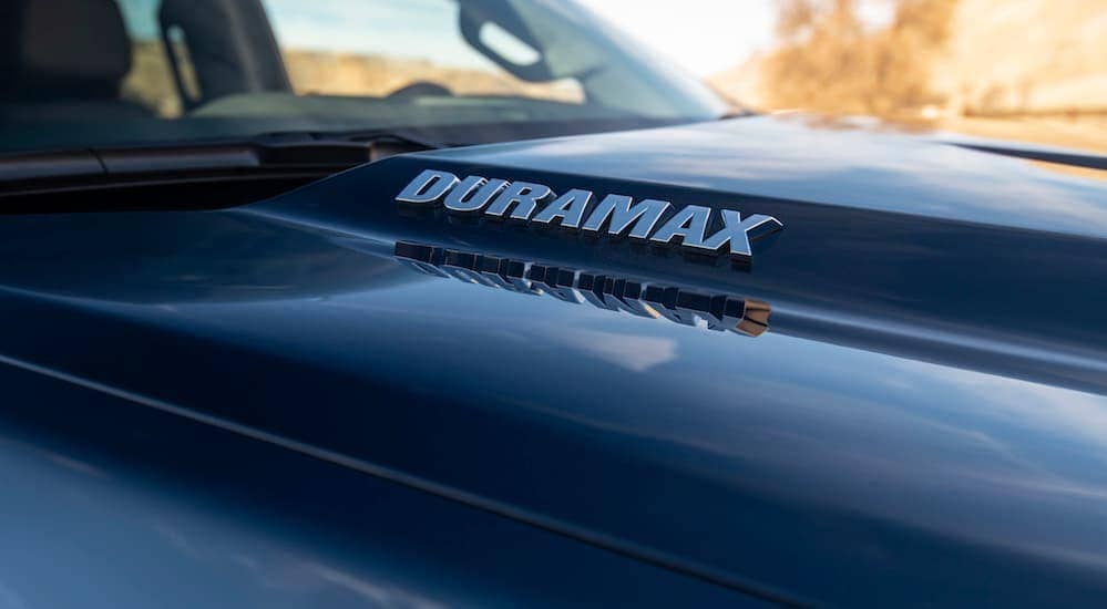 A Duramax logo is on a black hood of a 2020 Chevy Silverado 1500. 