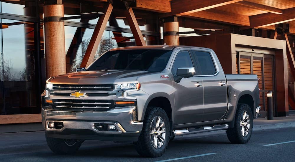 A silver Chevy Silverado Z71, which is a color you'll see when shopping for the Chevy Silverado Trail Boss vs Silverado Z71, is parked in front of an office building near Bethlehem, PA.