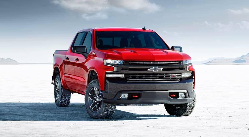 A red 2020 Chevy Silverado 1500 LT Trail Boss is parked on a flat salt land. 