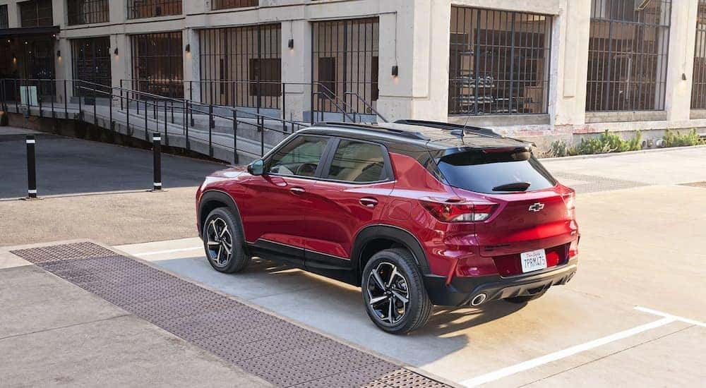 A red 2021 Chevy Trailblazer is shown from the rear in front of a city building.