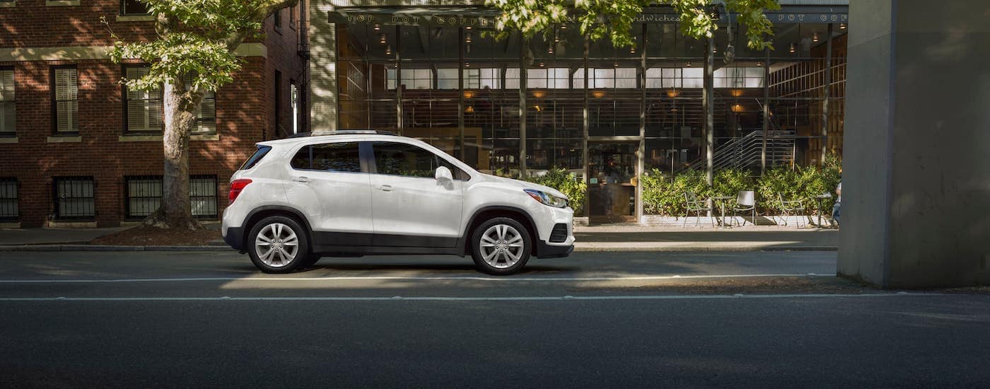 A white 2020 Chevy Trax under a bridge in front of a cafe