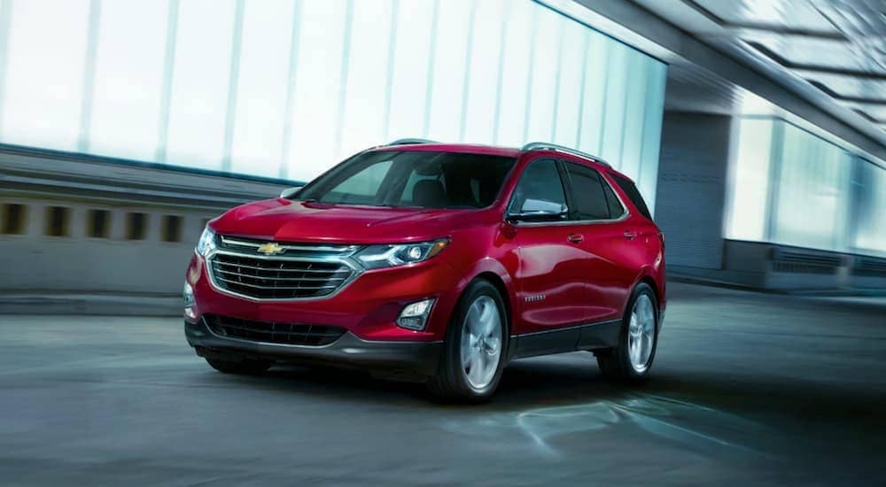 A red 2019 Chevy Traverse is driving past lit windows at night in Bethlehem, PA.