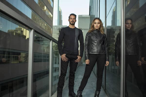 A young modern looking man and women wear sleek black clothes from the Harley-Davidson H-D Moto Collection.