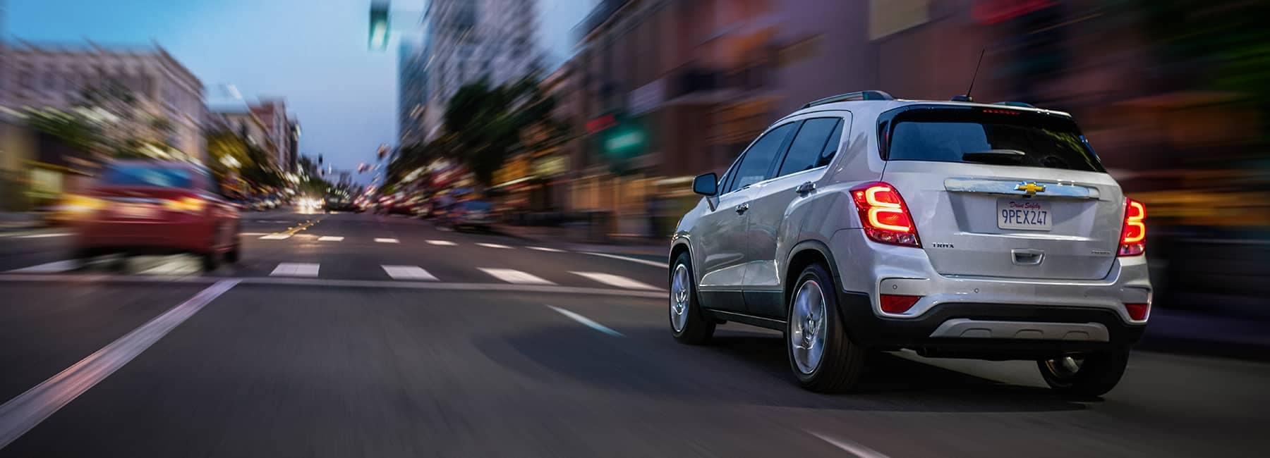 Silver 2020 Chevrolet Trax Driving on a City Rd