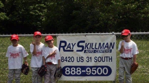 Children in front of a Ray Skillman advertisement