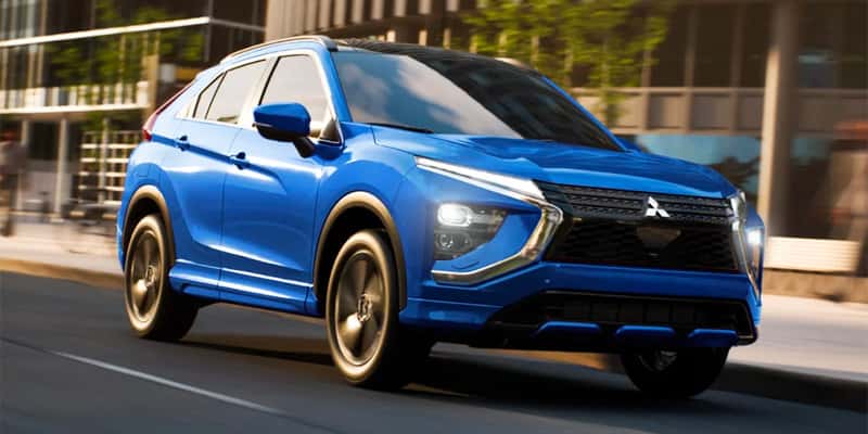 a blue 2025 Mitsubishi Eclipse Cross driving down a street