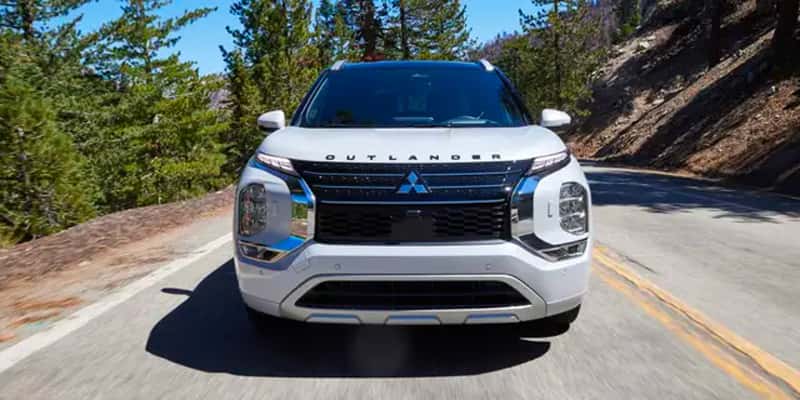 a white Mitsubishi Outlander PHEV on a mountain road