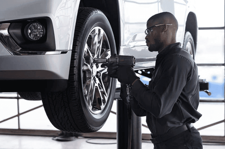 Certified-technician-tightens-bolts-on-tire