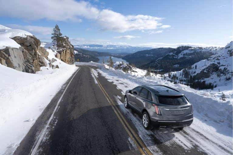 2020 Cadillac XT5 driving down snowy mountain road mobile