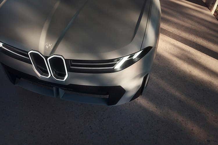 A close up shows the headlight on a silver BMW Vision Neue Klasse X.