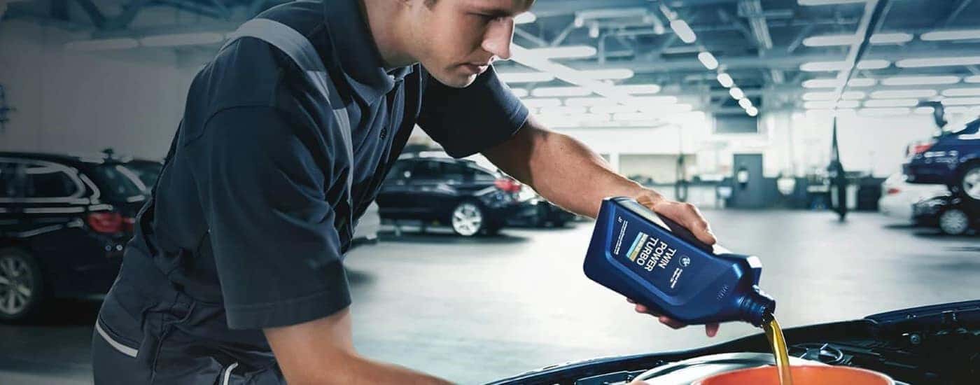A mechanic is shown during an oil change at a BMW dealer.