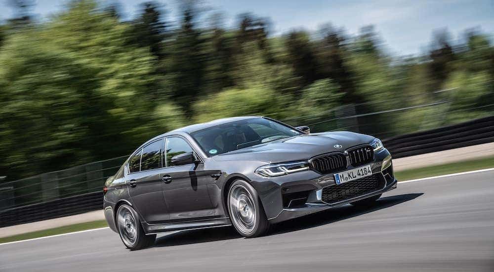 A grey 2024 BMW M5 Competition is shown from the front at an angle.
