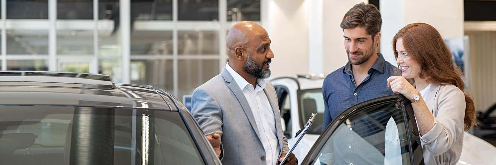 Employee showing customer features of a vehicle.