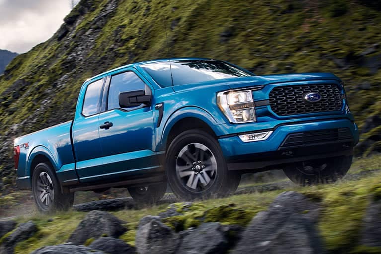 Blue 2021 Ford F-150 climbing a mountain road_mobile