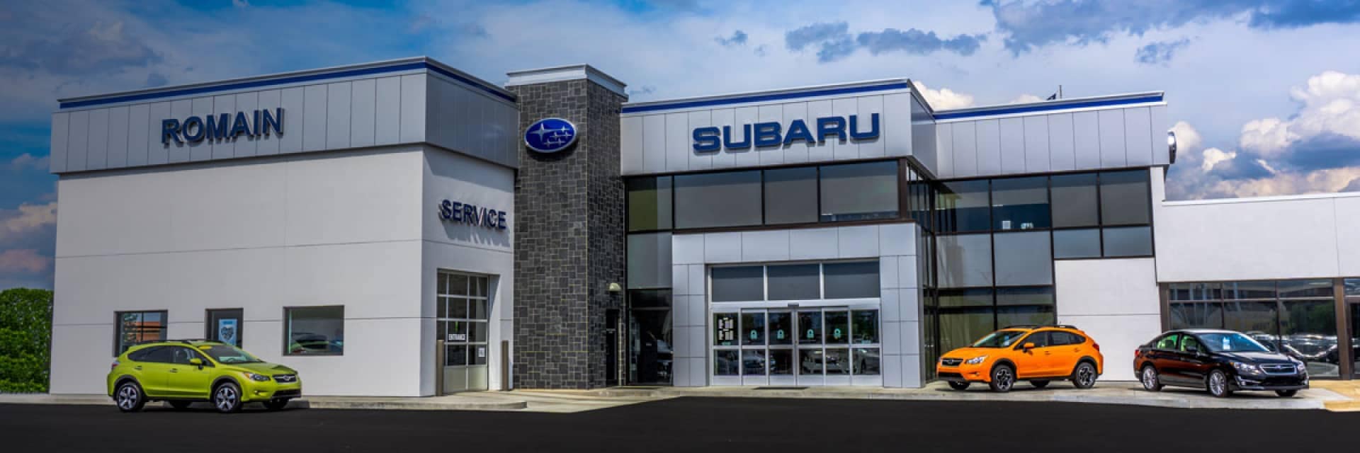 An exterior view of a Subaru dealership in the day
