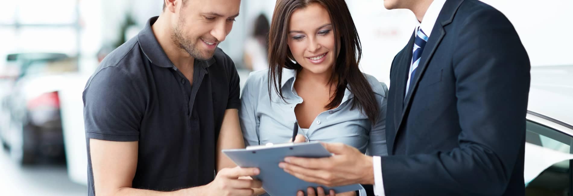 Man and Woman Looking at Documents with Dealer