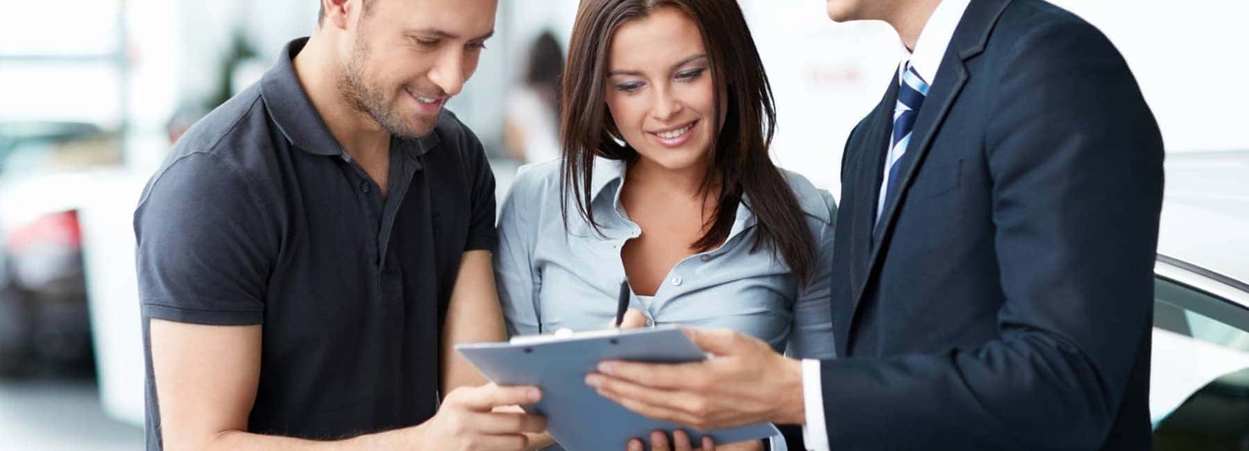 Man and a Woman Looking at Documents with Dealer