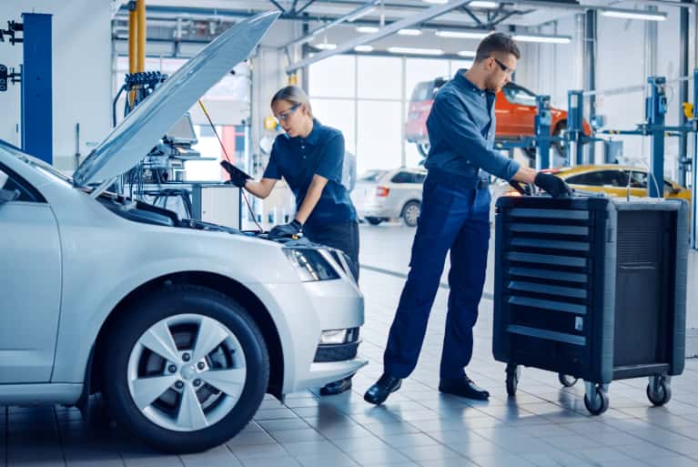 Two Service Technicians working on a car
