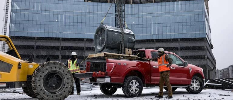 Construction workers loading up ford truck bed