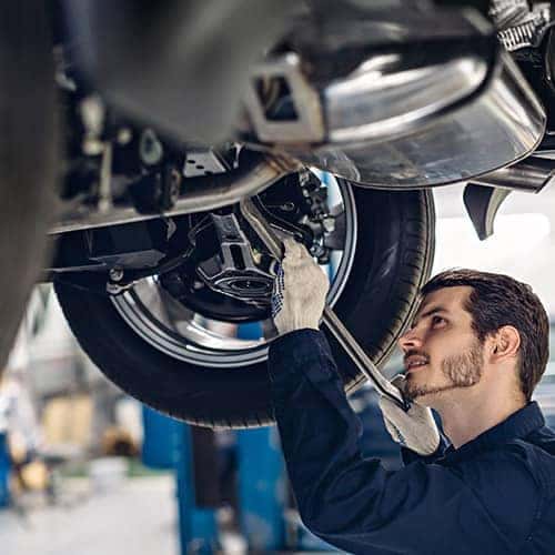 Service technician looking at car on a lift