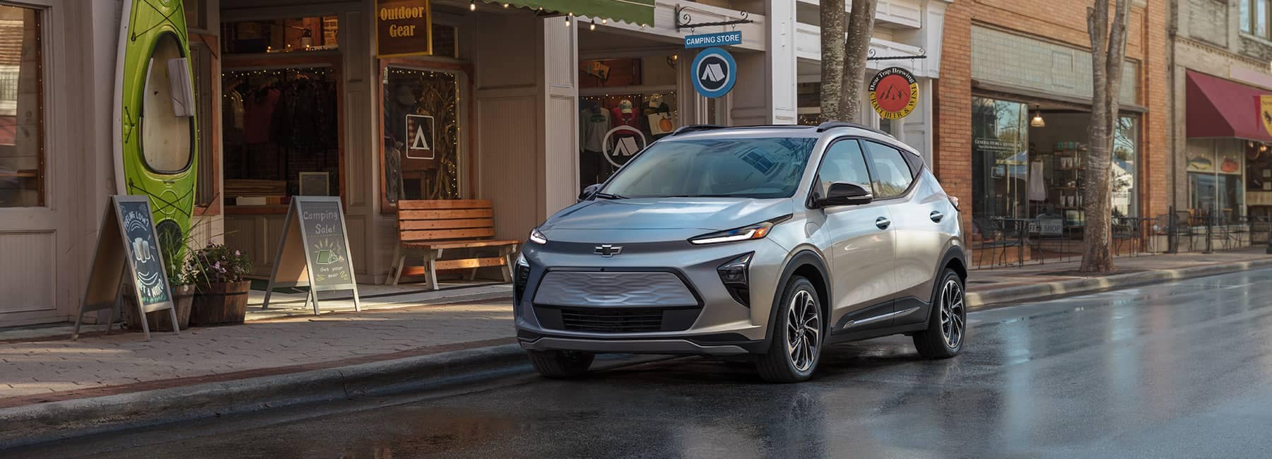 2022 Bolt EUV Premier in Silver Flare Metallic Parked in Front of Storefronts