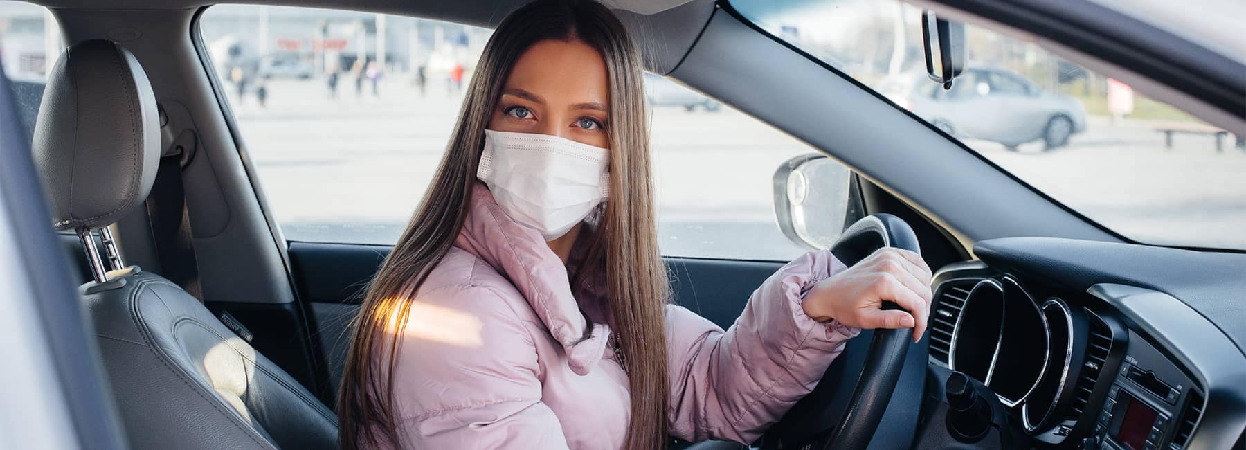 Woman in a Pink Coat Wearing a Mask and Driving a Chevy Vehicle