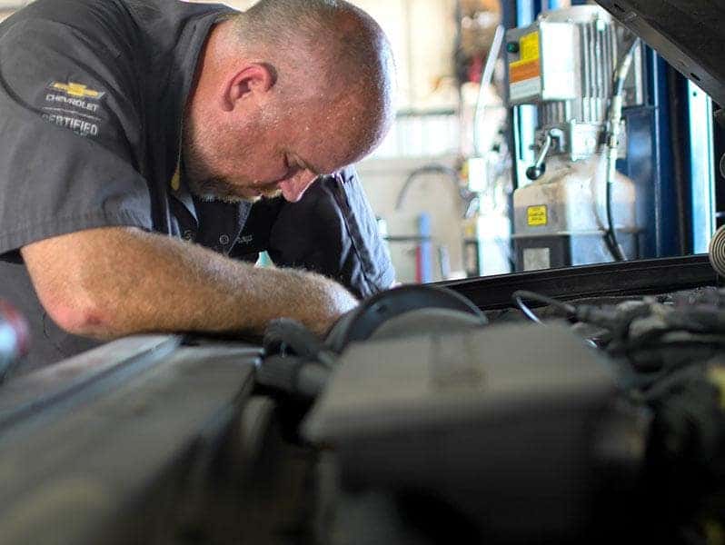 Service technician looking under the hood of a car