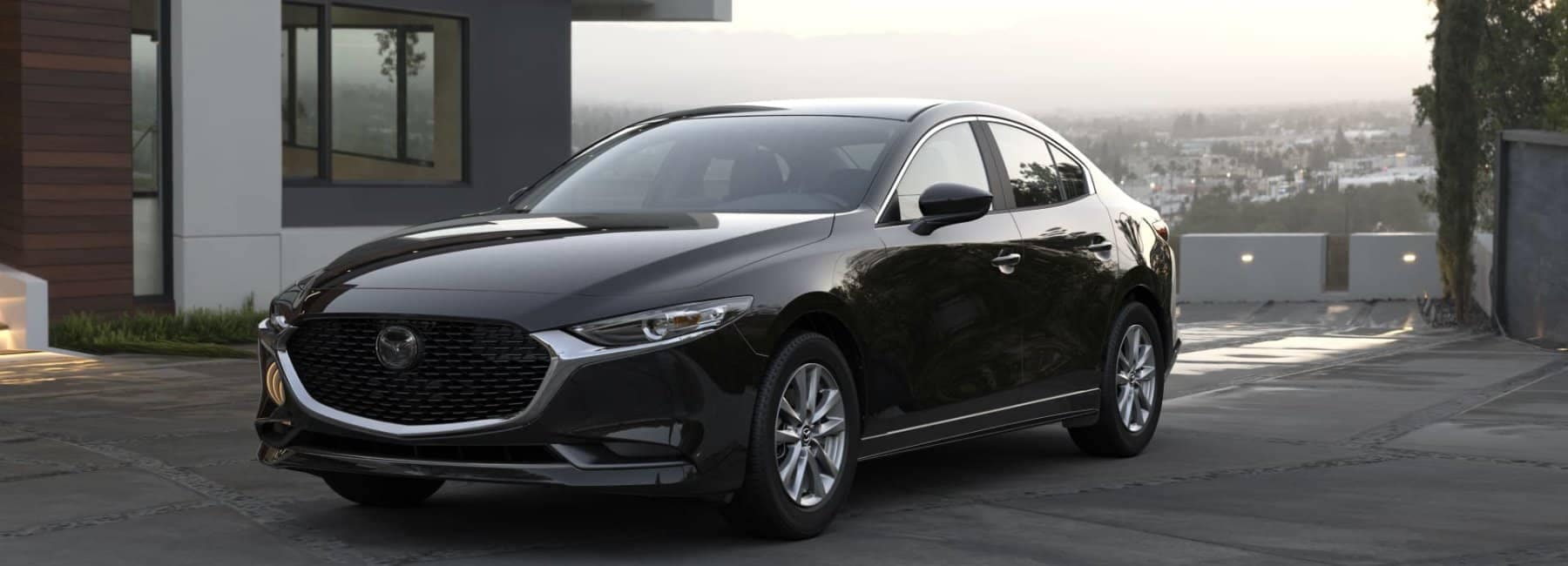 2022-mazda3-sedan-front-3qview-parked-house-driveway-cityview-black