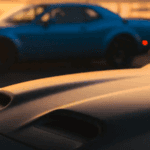 Closeup of vintage Challenger in foreground with modern Challenger in background