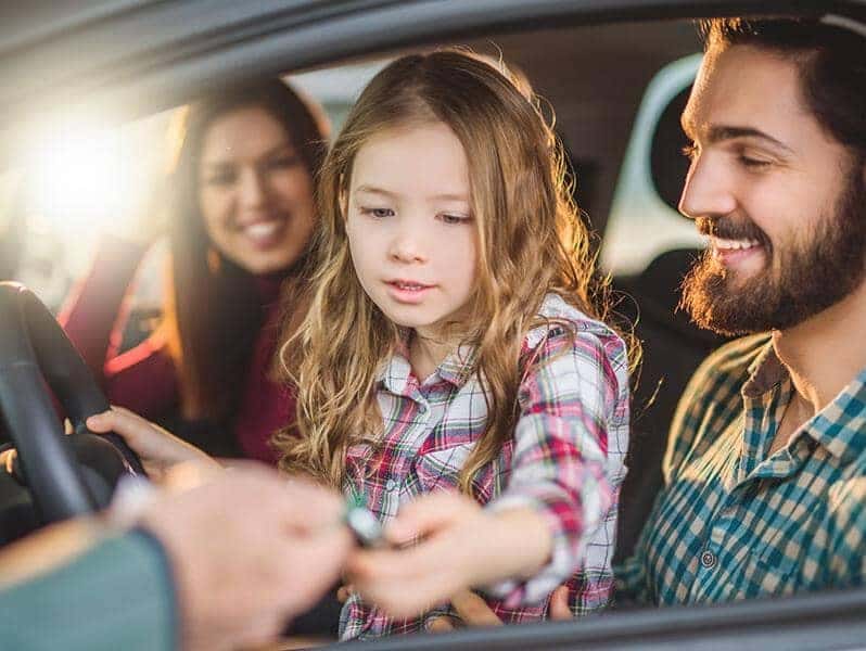 Family getting the keys to a vehicle handed to them