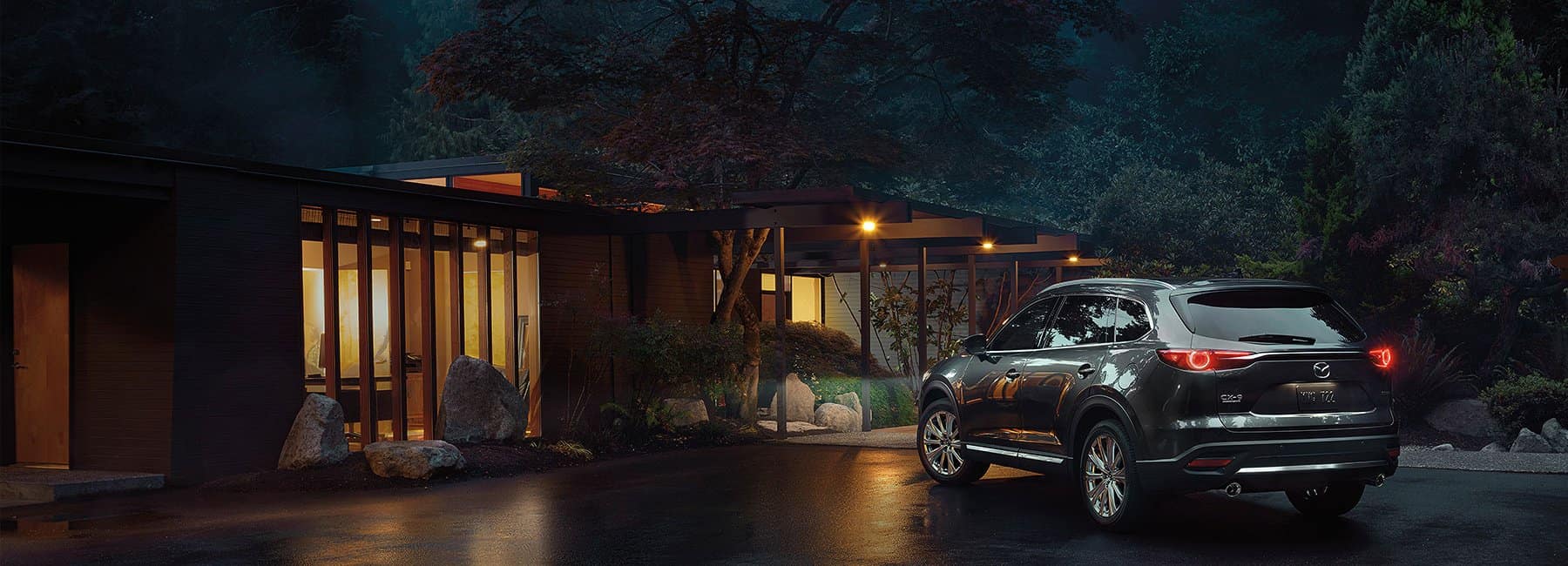 2022 Mazda CX-9 SUV-rear-3qview-parked-nighttime-modern house-forest-silver