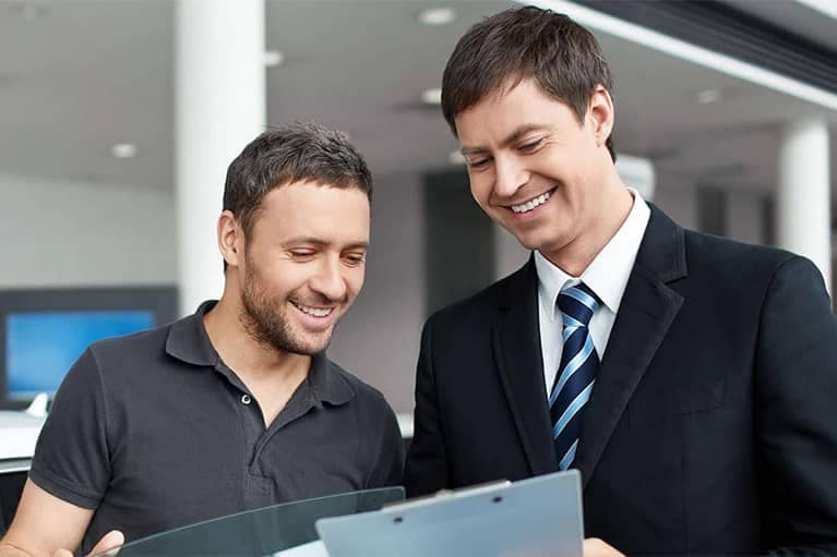 Man Looking at Documents with Dealer