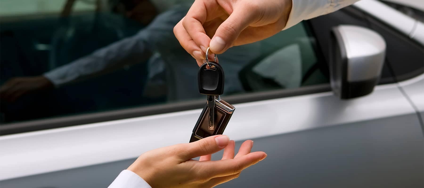 Person Handing Over Car Keys