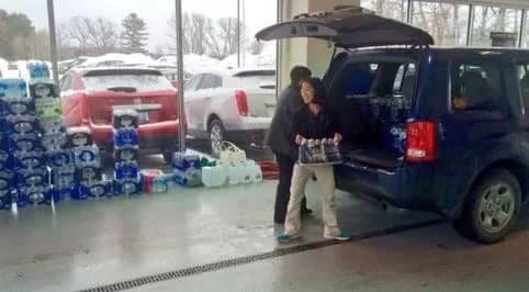 Woman unloading Subaru with bottled water