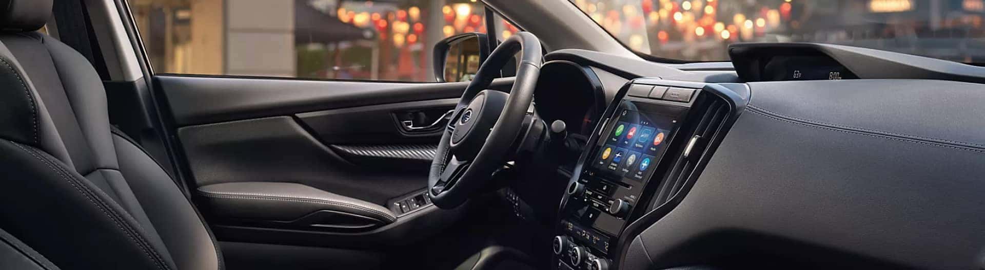 Interior shot of a Subaru dashboard and with steering wheel. 