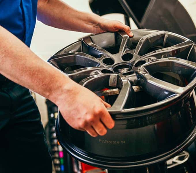 service mechanic installs tire